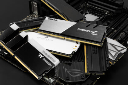 A glowing stick of high-performance DDR5 RAM held in front of a vibrant, out-of-focus gaming PC background, illustrating the importance of RAM for gaming in 2025.