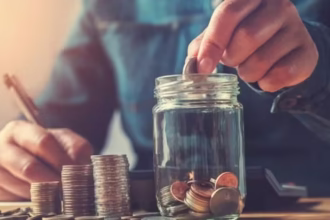 A person carefully placing a coin into a piggy bank, symbolizing the first step to save money on a low income.