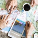 A diverse collage of travel destinations - a beach, a mountain, and a city - with the text "The Ultimate Beginner's Guide to Planning a Vacation" overlaid.