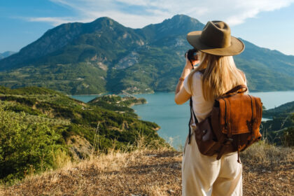 A solo traveler on a journey of self discovery travel, watching the sunrise over mountains.